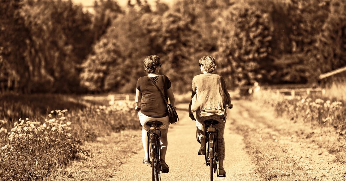 Cuide bem dos seus amigos. Dois amigos andando de bicicleta, aproveitando as coisas simples da vida.